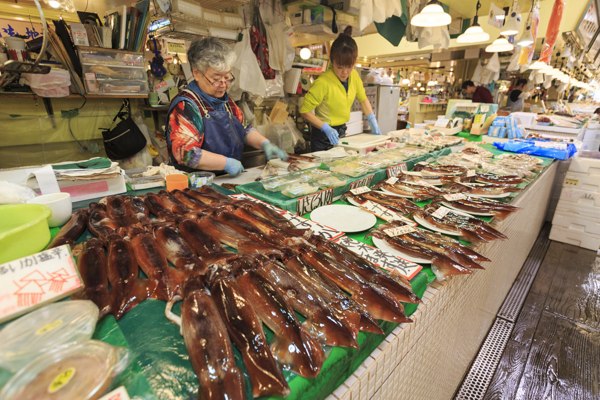 イカ、鮭、アワビ・ウニなど、人気のアイテムは専門店もあり。市内唯一のイカ専門店「富田鮮魚店」。店先で捌いてもらったイカ刺しを、市場内の休憩スペースで食べる観光客の姿も見られます。